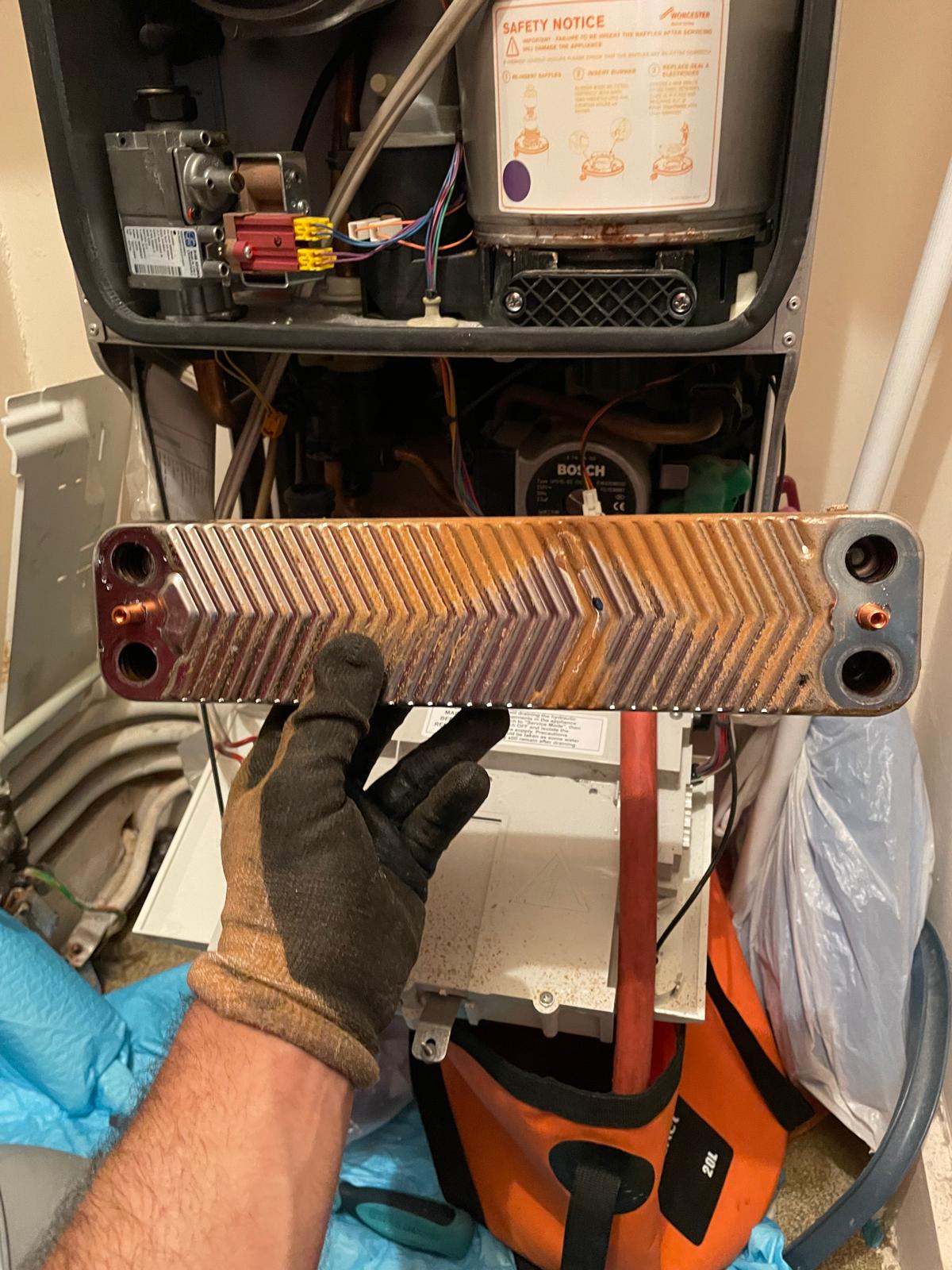 Corroded boiler heat exchanger removed during boiler repair in London home