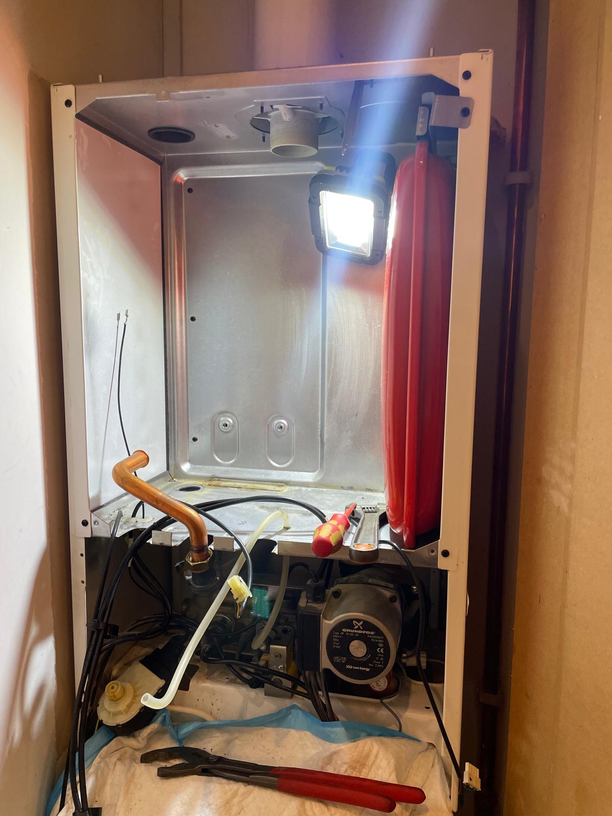 Boiler internals exposed showing expansion vessel and pump during maintenance