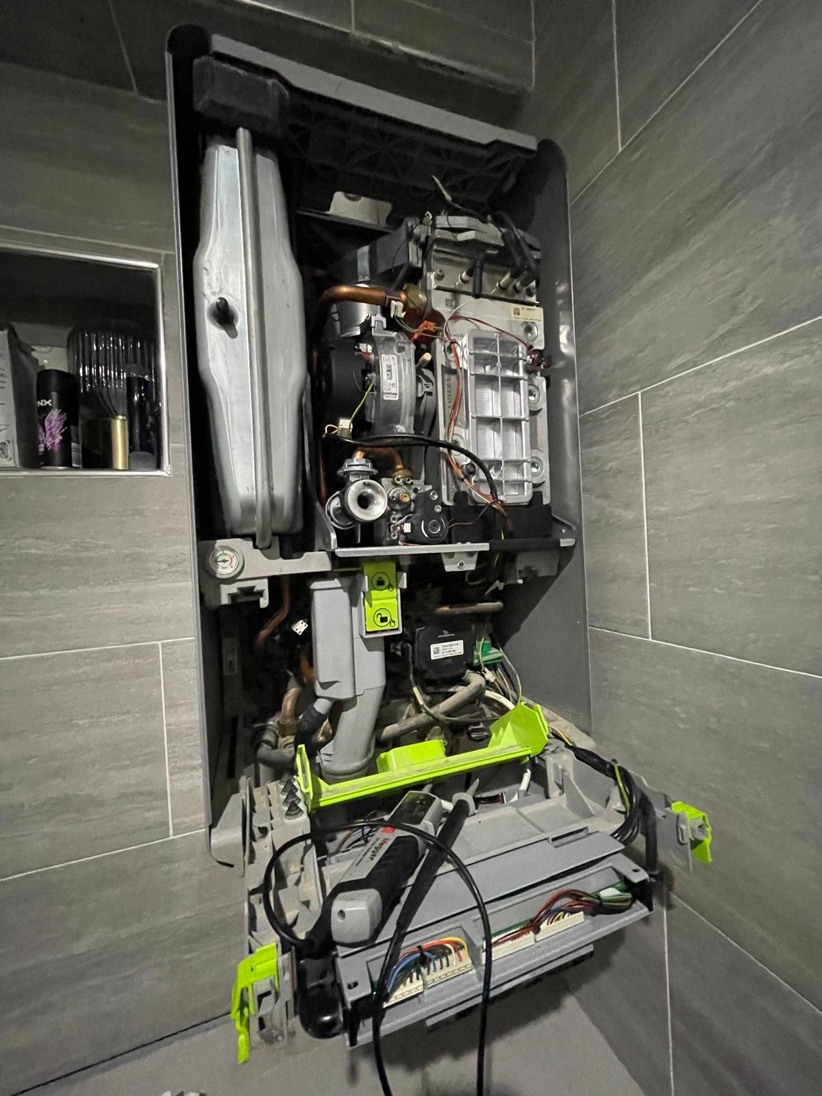 Modern condensing boiler opened for annual service inspection by Gas Safe engineer