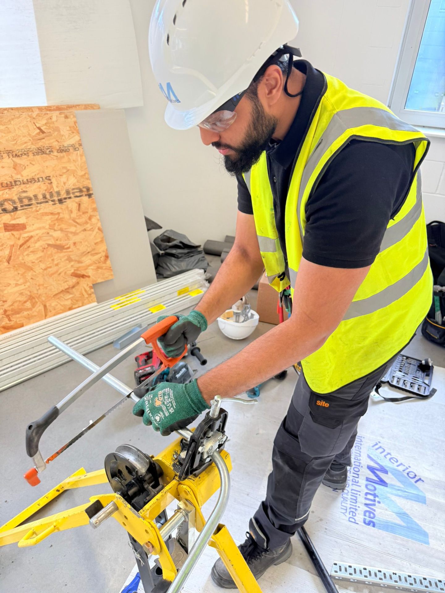MAMOSS engineer bending copper pipe using hydraulic pipe bender on construction site