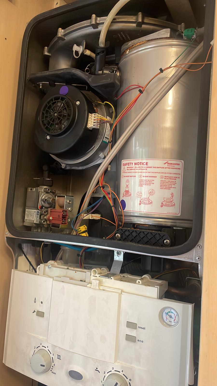 Worcester Bosch combi boiler servicing showing internal combustion chamber and wiring